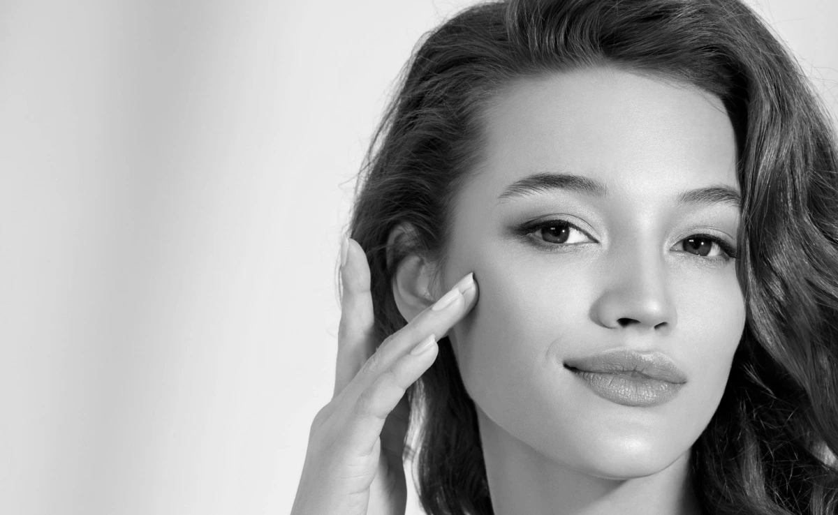 woman with flawless skin touching her face